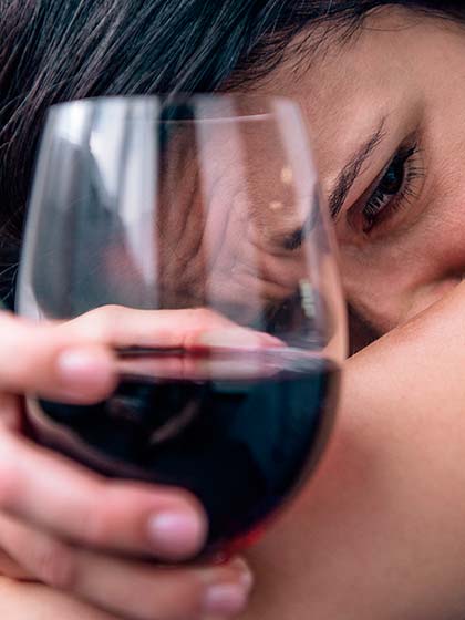 женщина плачет и держит в руке бокал вина крупным планом